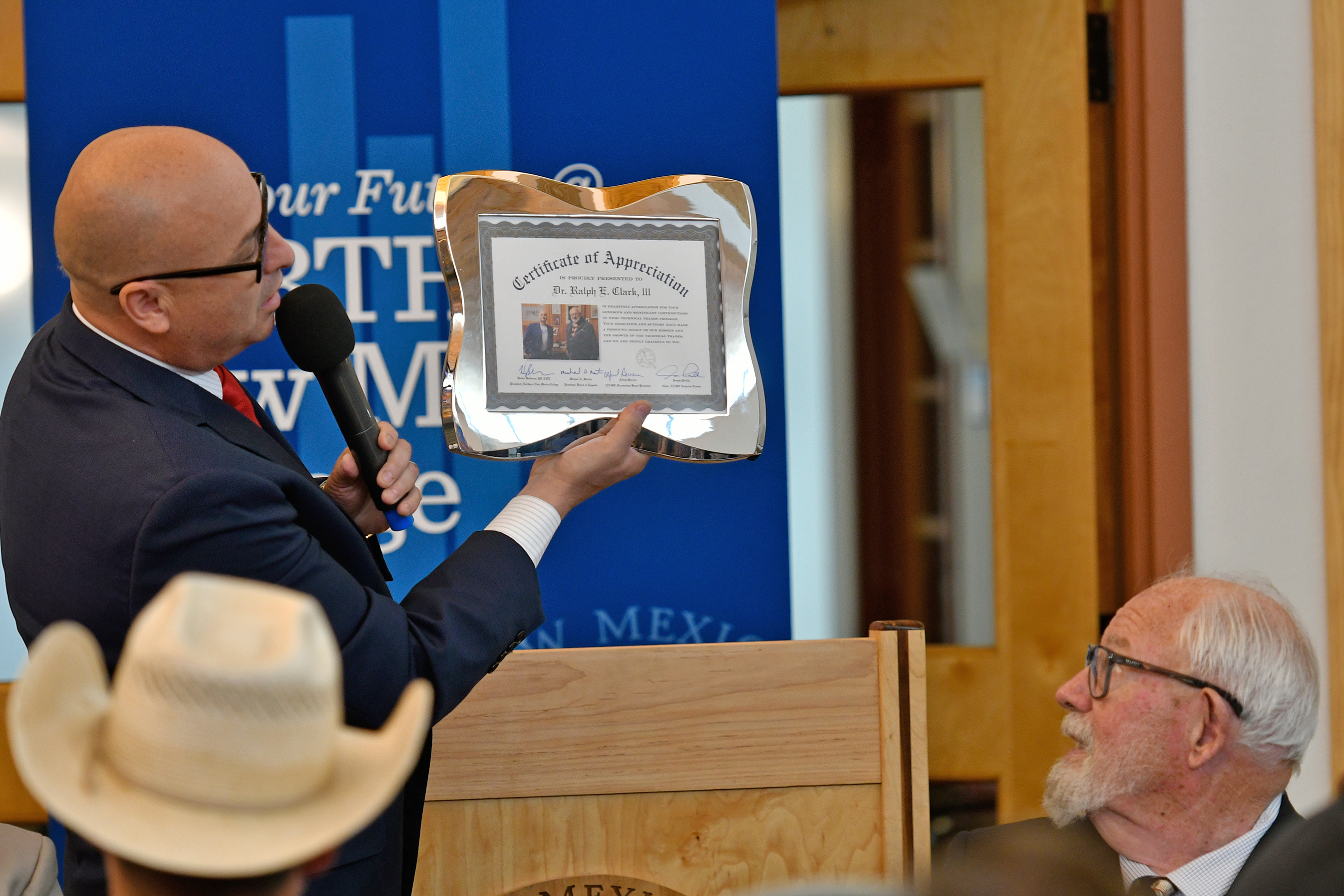 NNMC President Hector Balderas presents a Certificate of Appreciation to Butch Clark.